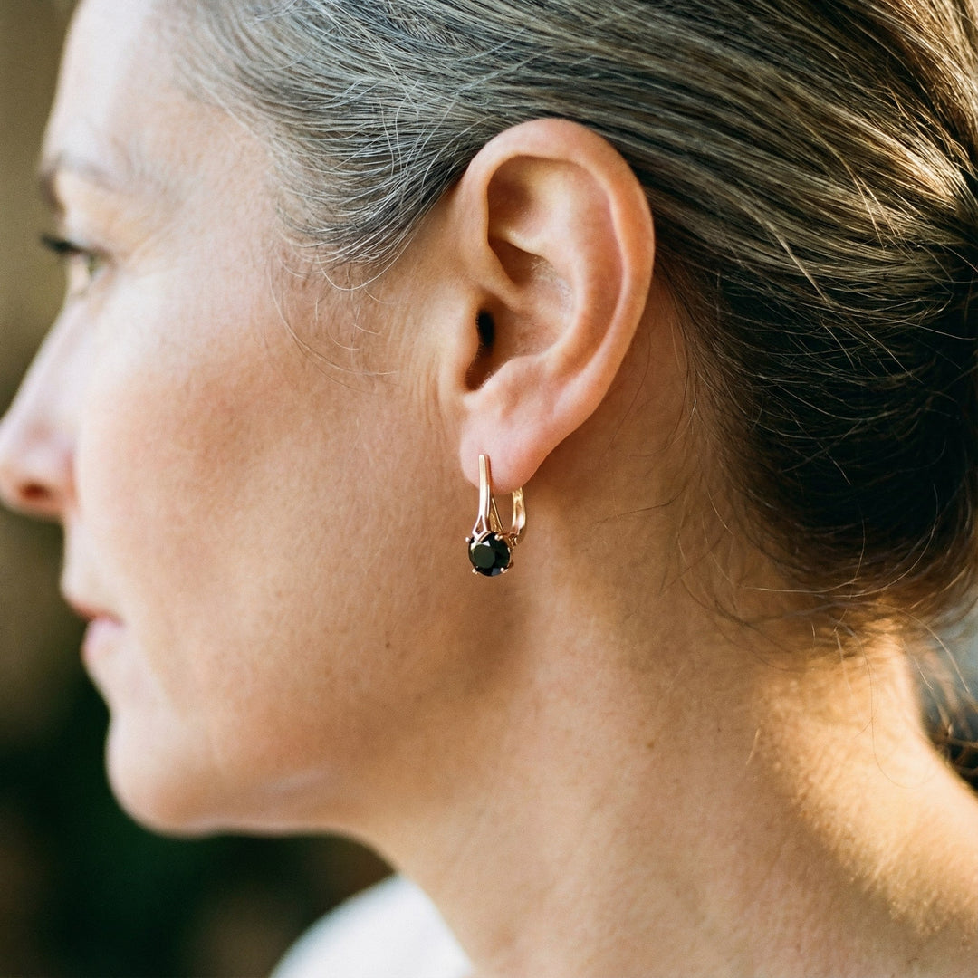 Elegant guldøreringe med sort zirkonia