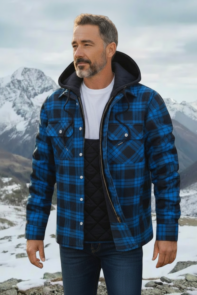 Mature model wearing blue plaid flannel jacket in snowy mountains