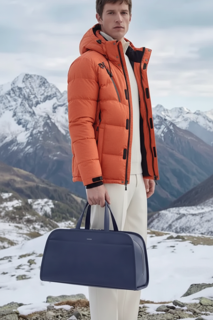 Model wearing orange parka in snowy mountains